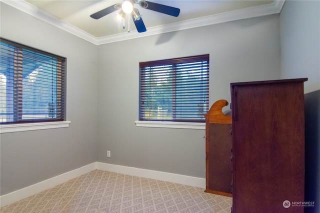 empty room featuring crown molding, light colored carpet, and ceiling fan