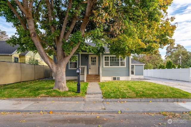 view of property hidden behind natural elements featuring a front lawn