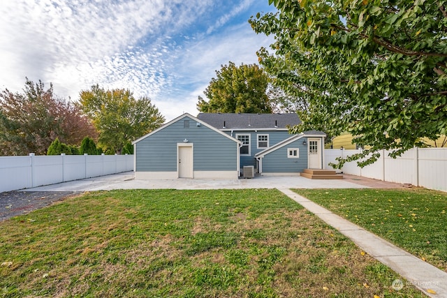 back of property with a yard, a patio area, and central air condition unit