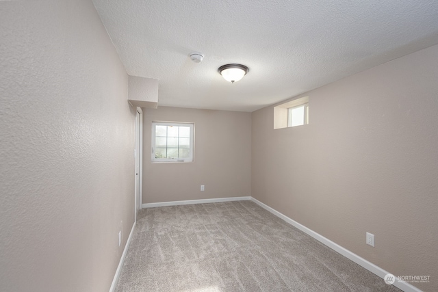 spare room featuring a textured ceiling and carpet