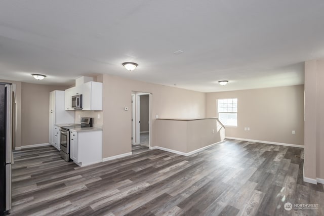 kitchen with white cabinetry, stainless steel appliances, and dark hardwood / wood-style floors