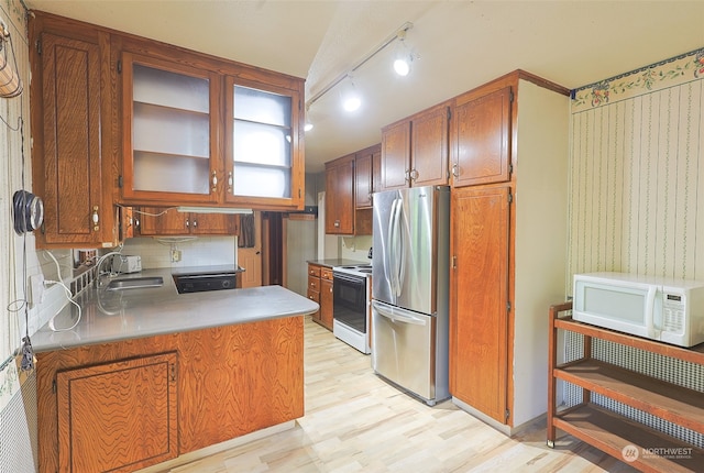 kitchen with sink, kitchen peninsula, white appliances, light hardwood / wood-style floors, and backsplash