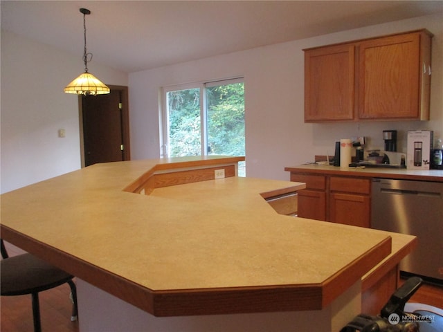 kitchen featuring a large island, decorative light fixtures, stainless steel dishwasher, dark wood-type flooring, and a breakfast bar