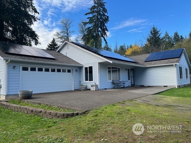 single story home with a garage, a front lawn, and solar panels