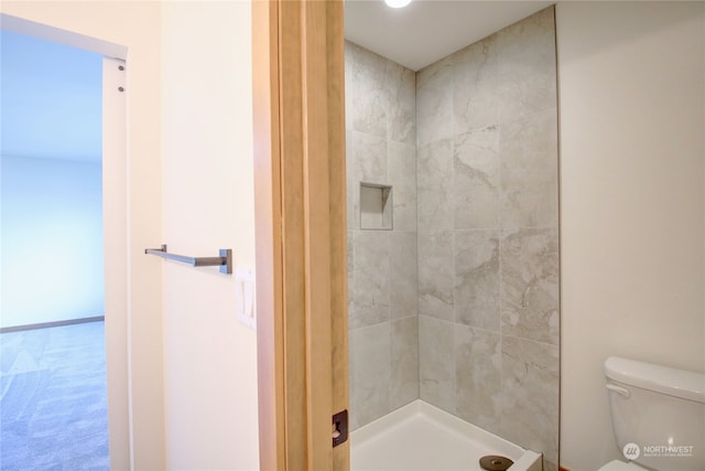 bathroom featuring toilet and tiled shower