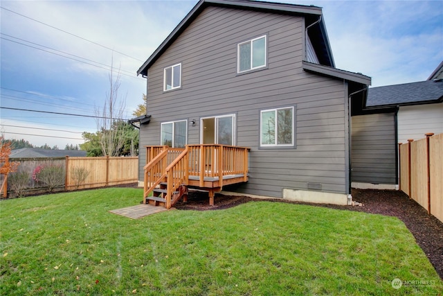 back of house featuring a lawn and a deck