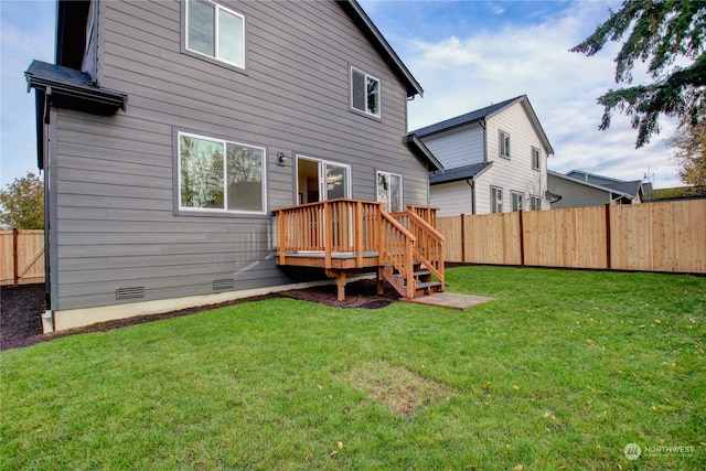 back of property with a deck and a lawn