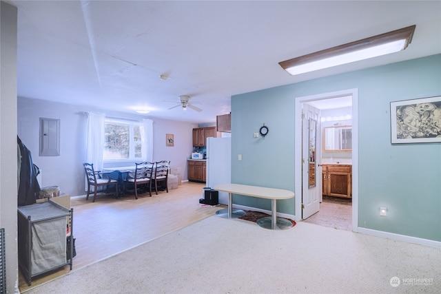 carpeted living room with ceiling fan and electric panel