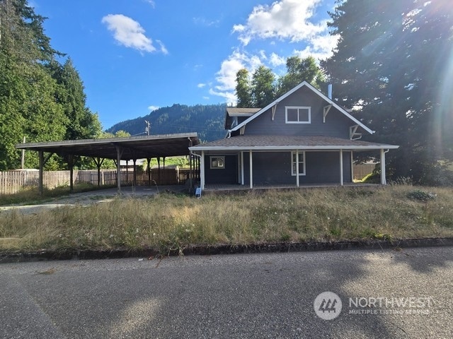 farmhouse-style home with a mountain view and a carport