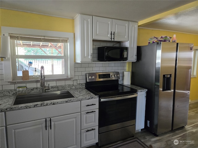 kitchen with decorative backsplash, white cabinetry, dark wood-type flooring, sink, and stainless steel appliances