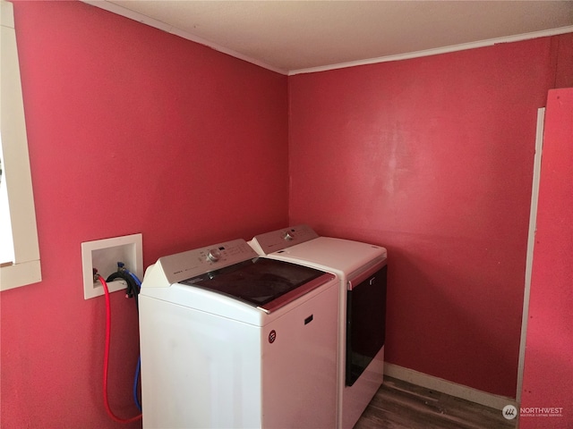 washroom featuring ornamental molding, dark wood-type flooring, and washing machine and clothes dryer