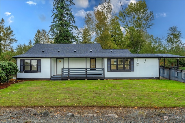 rear view of property featuring a yard and a deck