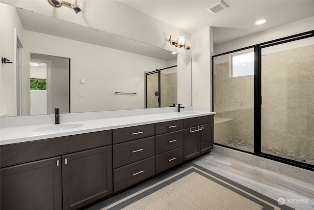 bathroom with vanity, an enclosed shower, and hardwood / wood-style flooring