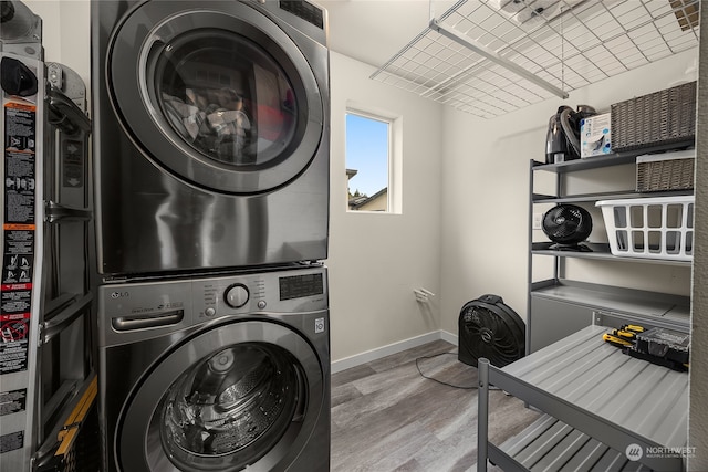 washroom with stacked washer and dryer and hardwood / wood-style flooring