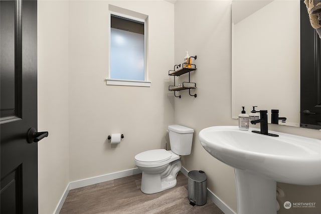 bathroom with hardwood / wood-style flooring and toilet