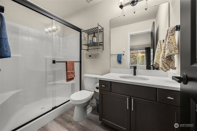 bathroom featuring hardwood / wood-style floors, vanity, toilet, a notable chandelier, and an enclosed shower