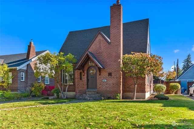 english style home featuring a front yard