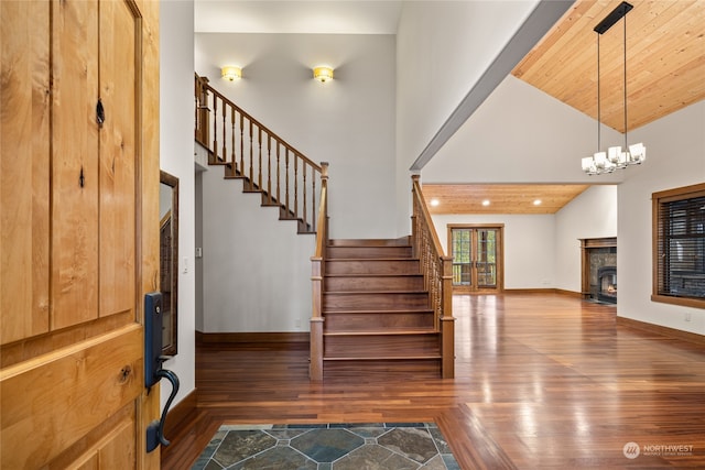 foyer featuring a chandelier, dark wood-type flooring, high vaulted ceiling, and wooden ceiling