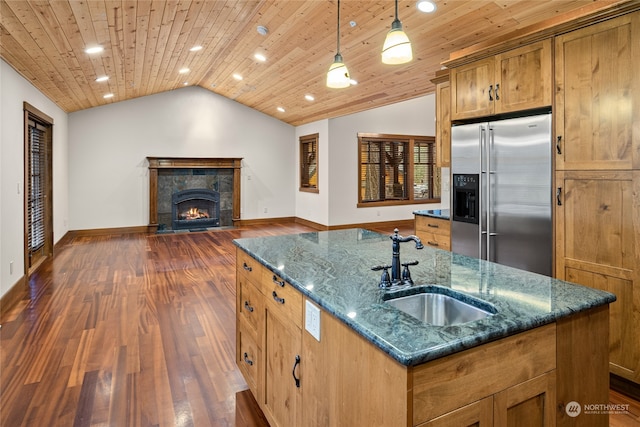 kitchen featuring lofted ceiling, dark hardwood / wood-style floors, stainless steel refrigerator with ice dispenser, hanging light fixtures, and sink