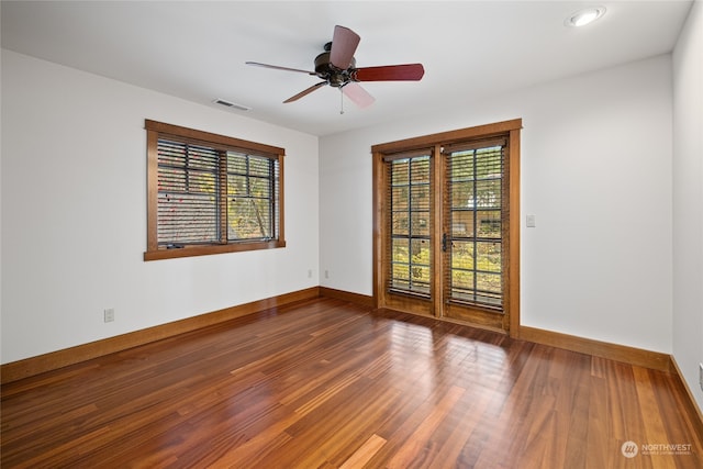 unfurnished room featuring ceiling fan, wood-type flooring, and plenty of natural light