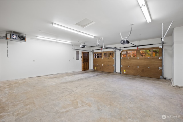 garage with a garage door opener and electric panel