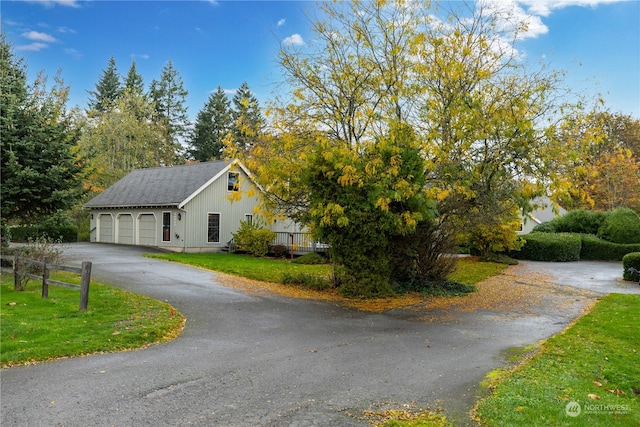 view of property exterior featuring a garage and a lawn