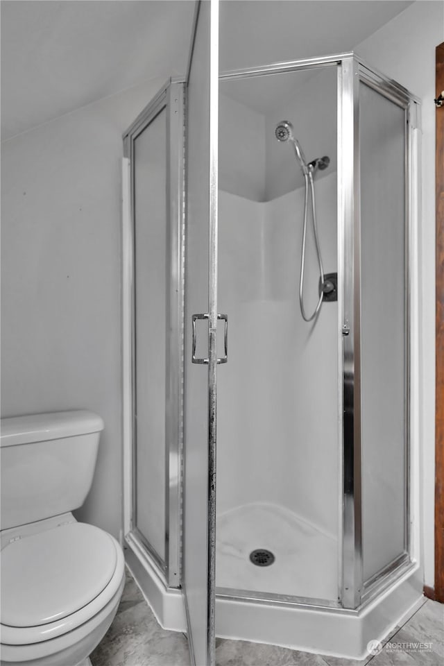 full bath featuring a shower stall, toilet, and marble finish floor