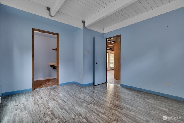 spare room with wood ceiling, beamed ceiling, and wood-type flooring