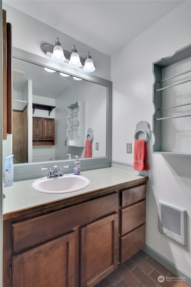 bathroom featuring baseboards, heating unit, brick floor, and vanity