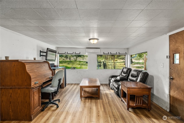 office area with an AC wall unit and light hardwood / wood-style flooring