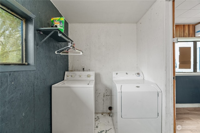 laundry area with hardwood / wood-style flooring and washing machine and dryer