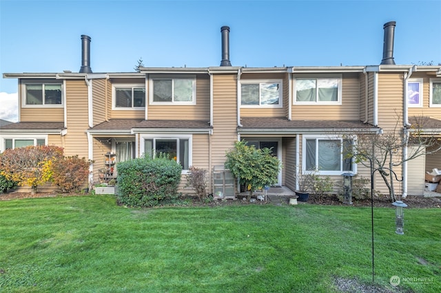 rear view of property featuring a lawn