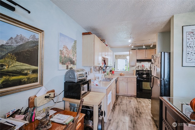 kitchen with a textured ceiling, sink, black appliances, light brown cabinets, and light hardwood / wood-style flooring