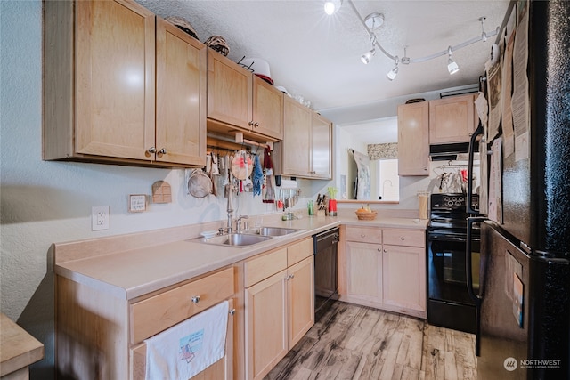 kitchen with light brown cabinetry, extractor fan, sink, black appliances, and light hardwood / wood-style flooring