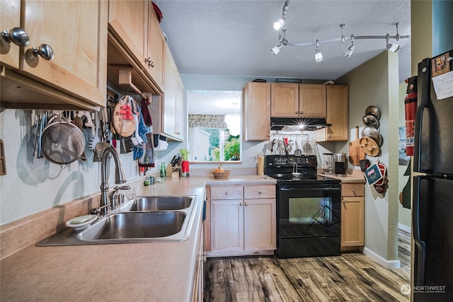 kitchen featuring hardwood / wood-style floors, sink, a textured ceiling, and black appliances