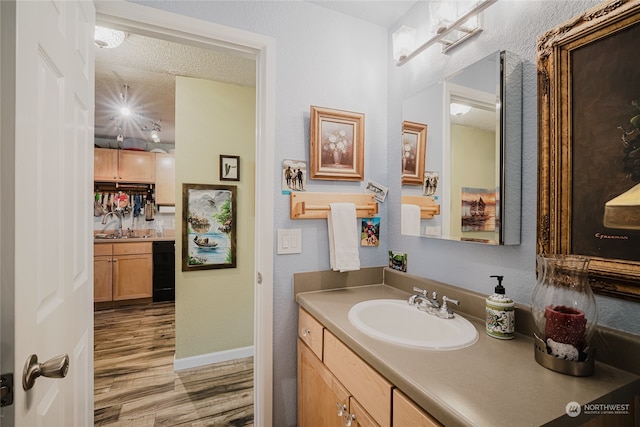 bathroom with vanity, wood-type flooring, and a textured ceiling