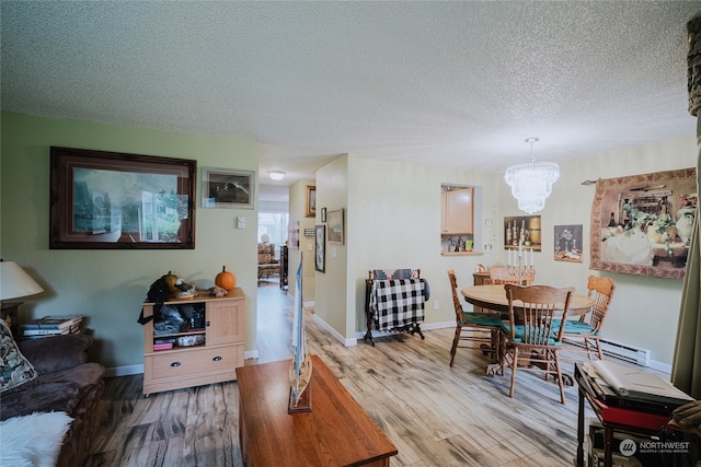 dining area with a chandelier, wood-type flooring, and a textured ceiling