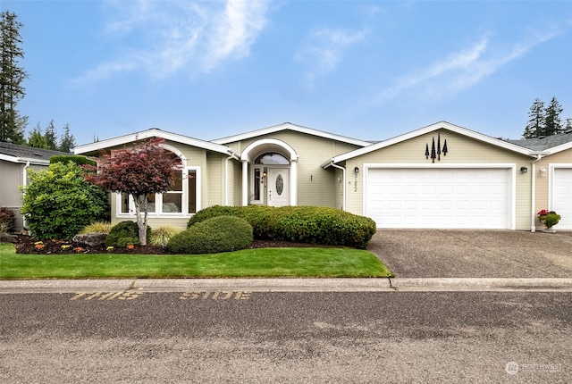 ranch-style house with a garage and a front lawn