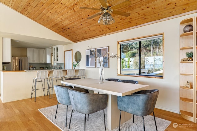 dining area with vaulted ceiling, light hardwood / wood-style flooring, wood ceiling, and ceiling fan