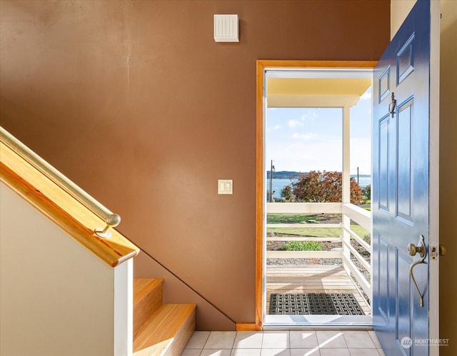 tiled entrance foyer with a water view