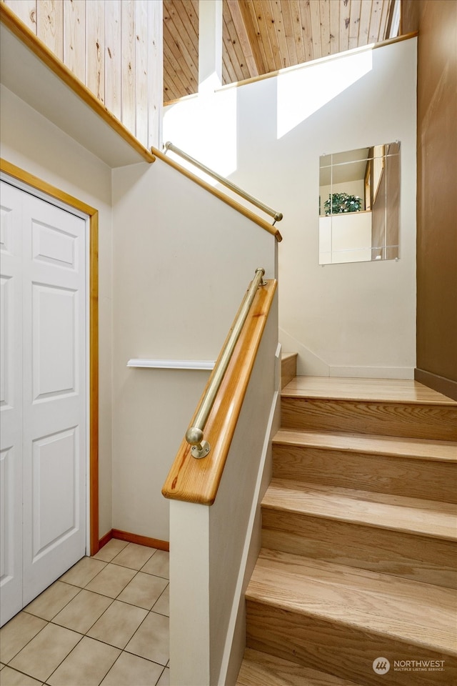 staircase with wood ceiling, tile patterned floors, and lofted ceiling