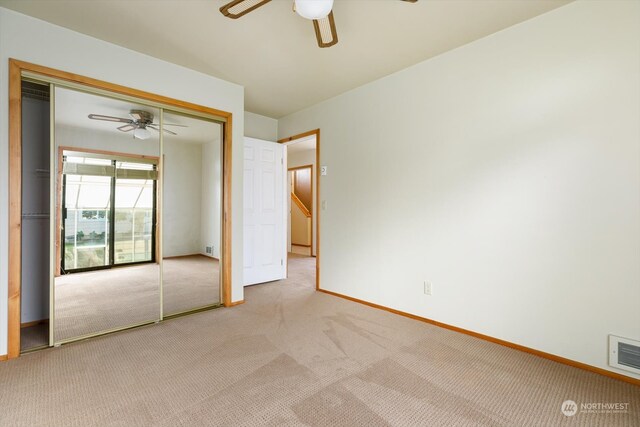 unfurnished bedroom with a closet, ceiling fan, and light colored carpet