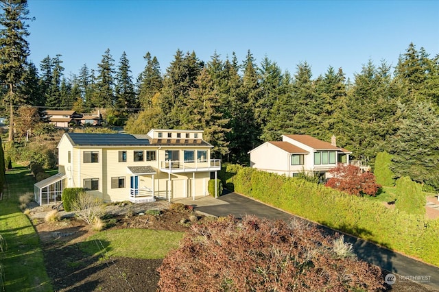 rear view of property with a balcony and a garage