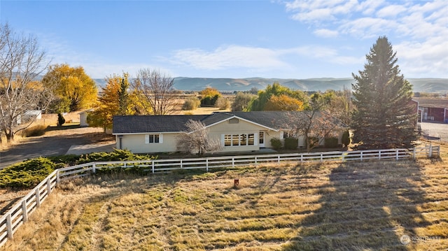 ranch-style house with a rural view and a mountain view