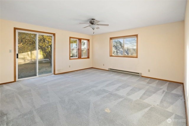 carpeted empty room featuring baseboard heating, ceiling fan, and plenty of natural light