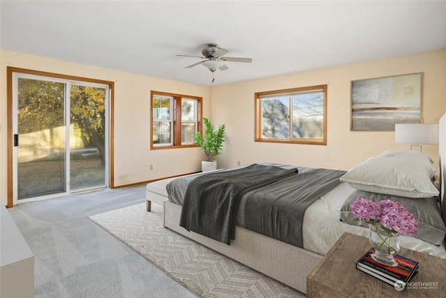 bedroom featuring access to exterior, light colored carpet, multiple windows, and ceiling fan