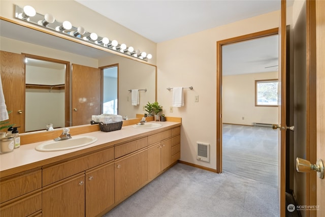 bathroom with vanity, heating unit, and baseboard heating