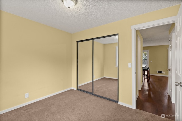 bedroom with a closet, hardwood / wood-style floors, and a textured ceiling