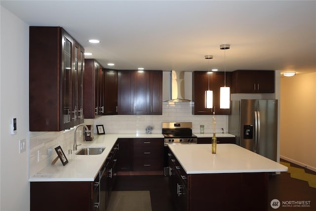 kitchen with appliances with stainless steel finishes, a sink, light countertops, wall chimney range hood, and backsplash