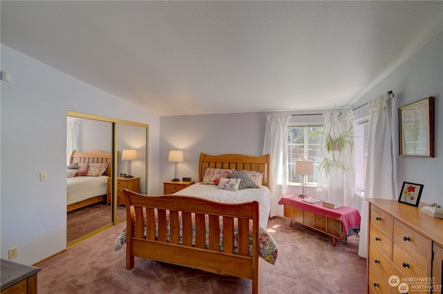 bedroom with carpet flooring, lofted ceiling, and a closet